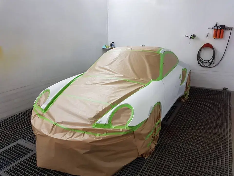 Abgeklebtes Fahrzeug in der Lackierkabine