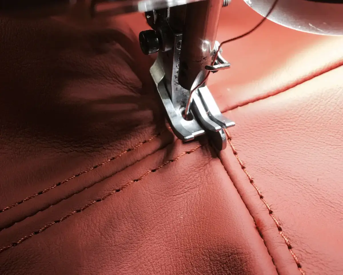 Nähmaschine näht rotes Leder mit Ziernaht